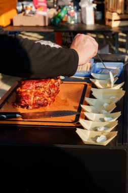 Etrafı servis tabakları ve barbekü aletleriyle çevrili ahşap bir tahtanın üzerinde leziz bir füme domuz rostosu. Yemek, yemek ve ızgara konsepti için ideal..