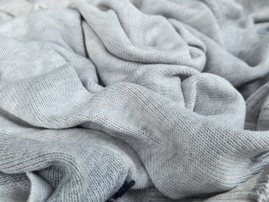 Kazağın yüzey dokusu yumuşak yünden örülmüş bir desen ile kırışmış..