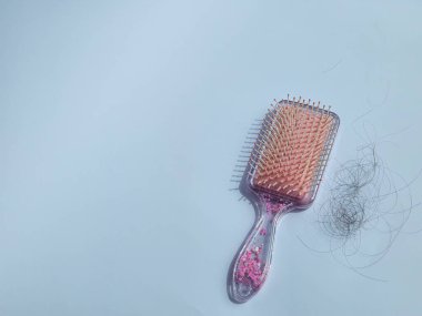 pink hair comb and hair that falls out after combing. isolated on white background