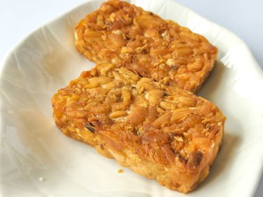 Beyaz arkaplanda izole edilmiş tabakta kızarmış tempeh kabı