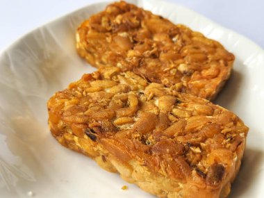 Beyaz arkaplanda izole edilmiş tabakta kızarmış tempeh kabı