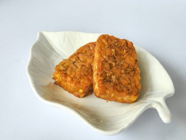 Beyaz arkaplanda izole edilmiş tabakta kızarmış tempeh kabı