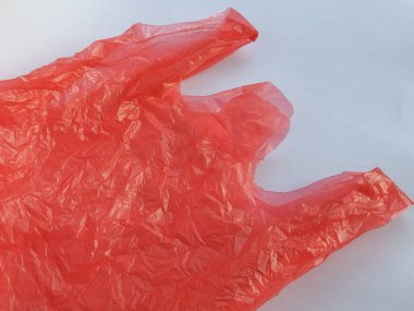 Şeffaf kırmızı kırışık beyaz arka planı olan plastik poşet.