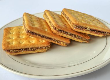 İki katmanlı çıtır bisküvi tabağı, beyaz arka planda izole edilmiş çikolata kremalı.