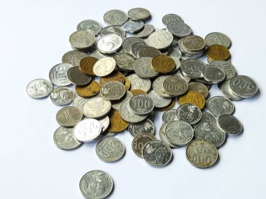 Beyaz arkaplanda 100, 200, 500 ve 1000 rupia 'lık madeni paralar yığını