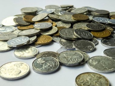 Beyaz arkaplanda 100, 200, 500 ve 1000 rupia 'lık madeni paralar yığını