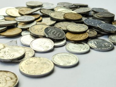 Beyaz arkaplanda 100, 200, 500 ve 1000 rupia 'lık madeni paralar yığını