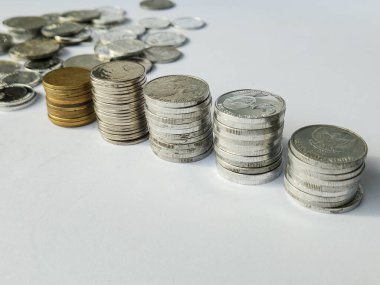 Beyaz arkaplanda 100, 200, 500 ve 1000 rupia 'lık madeni paralar yığını