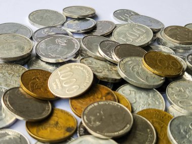Beyaz arkaplanda 100, 200, 500 ve 1000 rupia 'lık madeni paralar yığını