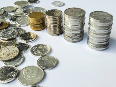 Beyaz arkaplanda 100, 200, 500 ve 1000 rupia 'lık madeni paralar yığını