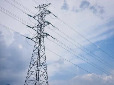 Yüksek voltajlı elektrik kabloları olan çelik inşaat kulesi.