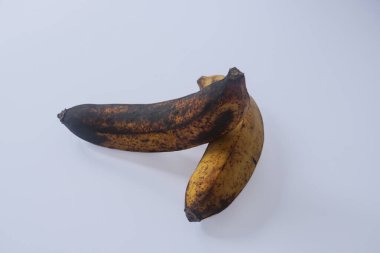 Beyaz arka planda izole edilmiş olgun ve neredeyse çürümüş bir muz.