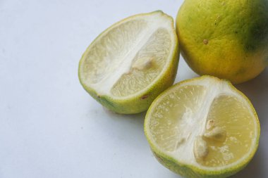 Bütün bir kireçin dış ve iç yüzey dokusu ve beyaz bir arka planda iki parçaya ayrılmış bir kireç.