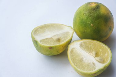 Bütün bir kireçin dış ve iç yüzey dokusu ve beyaz bir arka planda iki parçaya ayrılmış bir kireç.