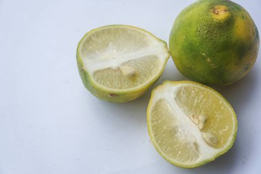 Bütün bir kireçin dış ve iç yüzey dokusu ve beyaz bir arka planda iki parçaya ayrılmış bir kireç.