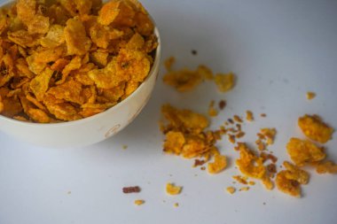 Beyaz arka planda izole edilmiş mısır cipsi kasesinde.