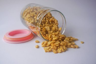 Beyaz arka planda izole edilmiş cam kavanozdaki tuzlu fıstık atıştırmalıkları.