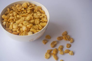 Beyaz arka planda izole edilmiş kasede tuzlu fıstık atıştırmalığı.