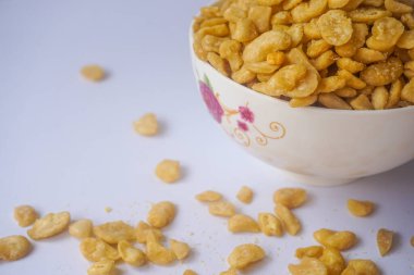 Beyaz arka planda izole edilmiş kasede tuzlu fıstık atıştırmalığı.