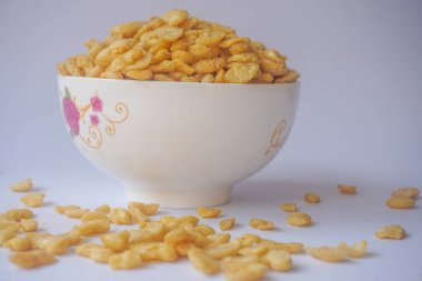 Beyaz arka planda izole edilmiş kasede tuzlu fıstık atıştırmalığı.