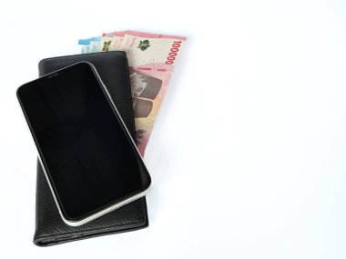 Deri cüzdanda rupiah banknotlar ve beyaz arka planda izole cep telefonu