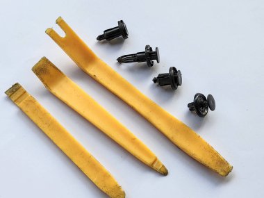 Araba gövdesi bileşenlerinde klempleri açmak için çeşitli sarı plastik manivela araçları ve beyaz arkaplan ile izole edilmiş 4 tür plastik kıskaç