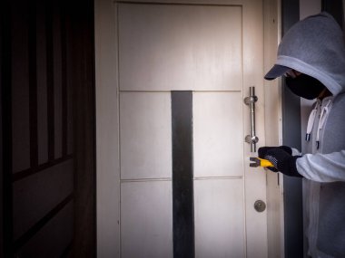 Bir hırsızın levye kullanarak evin kapısını açtığı görüntüsü.