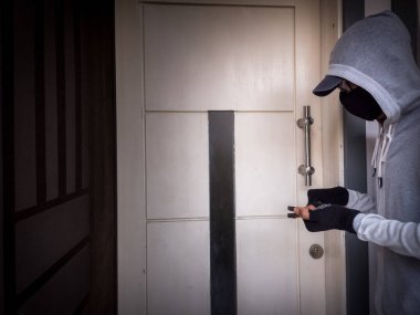 Bir hırsızın levye kullanarak evin kapısını açtığı görüntüsü.