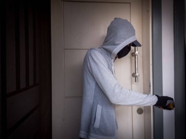 Bir hırsızın levye kullanarak evin kapısını açtığı görüntüsü.