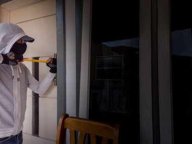 Bir hırsızın levye kullanarak evin kapısını açtığı görüntüsü.