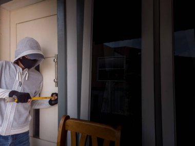 Bir hırsızın levye kullanarak evin kapısını açtığı görüntüsü.