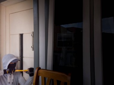 Bir hırsızın levye kullanarak evin kapısını açtığı görüntüsü.