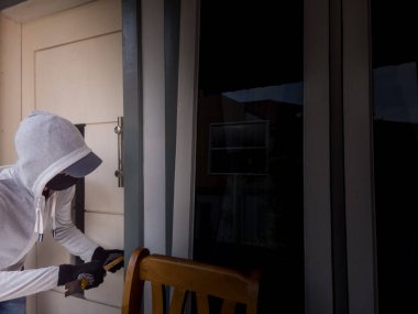 Bir hırsızın levye kullanarak evin kapısını açtığı görüntüsü.