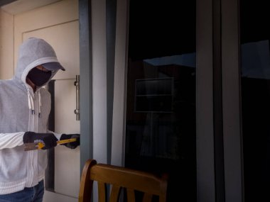 Bir hırsızın levye kullanarak evin kapısını açtığı görüntüsü.