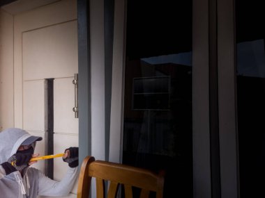 Bir hırsızın levye kullanarak evin kapısını açtığı görüntüsü.