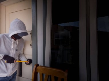 Bir hırsızın levye kullanarak evin kapısını açtığı görüntüsü.