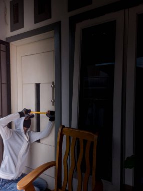 Bir hırsızın levye kullanarak evin kapısını açtığı görüntüsü.