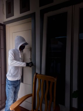Bir hırsızın levye kullanarak evin kapısını açtığı görüntüsü.