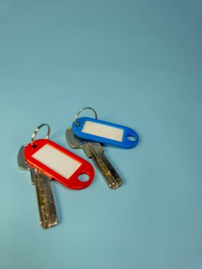 Açık mavi arkaplanda izole edilmiş anahtarlıklı iki kapı anahtarı