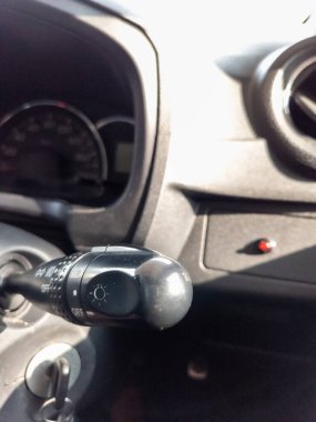 Bir arabanın direksiyonundaki sinyal kolunu çevir.