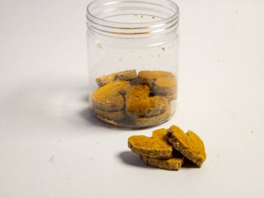 Kalp şeklinde fıstık kurabiyeleri ve beyaz arka planda izole edilmiş temiz kavanoz.