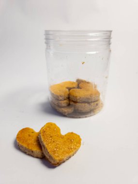 Kalp şeklinde fıstık kurabiyeleri ve beyaz arka planda izole edilmiş temiz kavanoz.