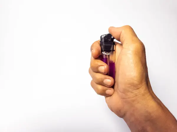 Bir adamın eli, beyaz arka planda izole edilmiş bir çakmağı tutuyor.