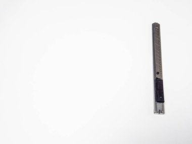 Bu yakın plan fotoğraf temiz, beyaz arka planda köşegende duran gümüş bir alet bıçağını gösteriyor. Görüntü bıçağın keskin bıçağını ve metal dokusunu vurguluyor. Kompozisyon aracın tasarımı ve hassasiyetini vurgular. Işıklandırma kreası