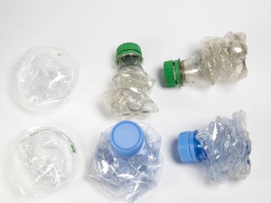 Bazıları çoktan ezilmiş ve geri dönüştürülmeye hazır plastik şişeler. Beyaz arkaplanda izole