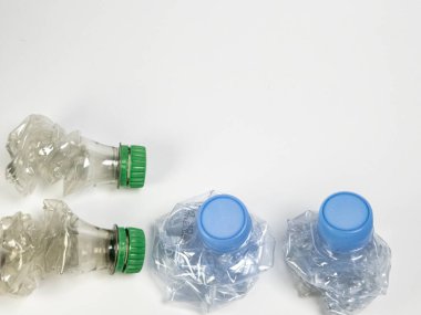 Bazıları çoktan ezilmiş ve geri dönüştürülmeye hazır plastik şişeler. Beyaz arkaplanda izole
