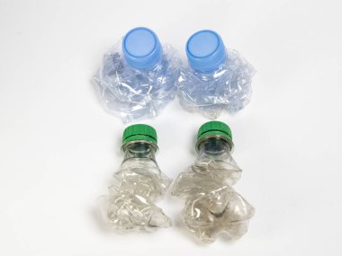 Bazıları çoktan ezilmiş ve geri dönüştürülmeye hazır plastik şişeler. Beyaz arkaplanda izole