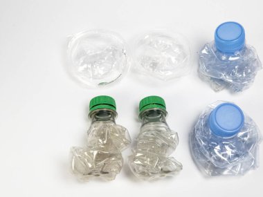 Bazıları çoktan ezilmiş ve geri dönüştürülmeye hazır plastik şişeler. Beyaz arkaplanda izole
