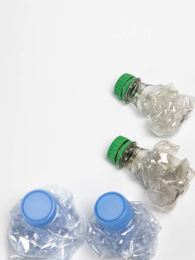 Bazıları çoktan ezilmiş ve geri dönüştürülmeye hazır plastik şişeler. Beyaz arkaplanda izole