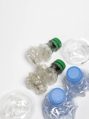 Bazıları çoktan ezilmiş ve geri dönüştürülmeye hazır plastik şişeler. Beyaz arkaplanda izole